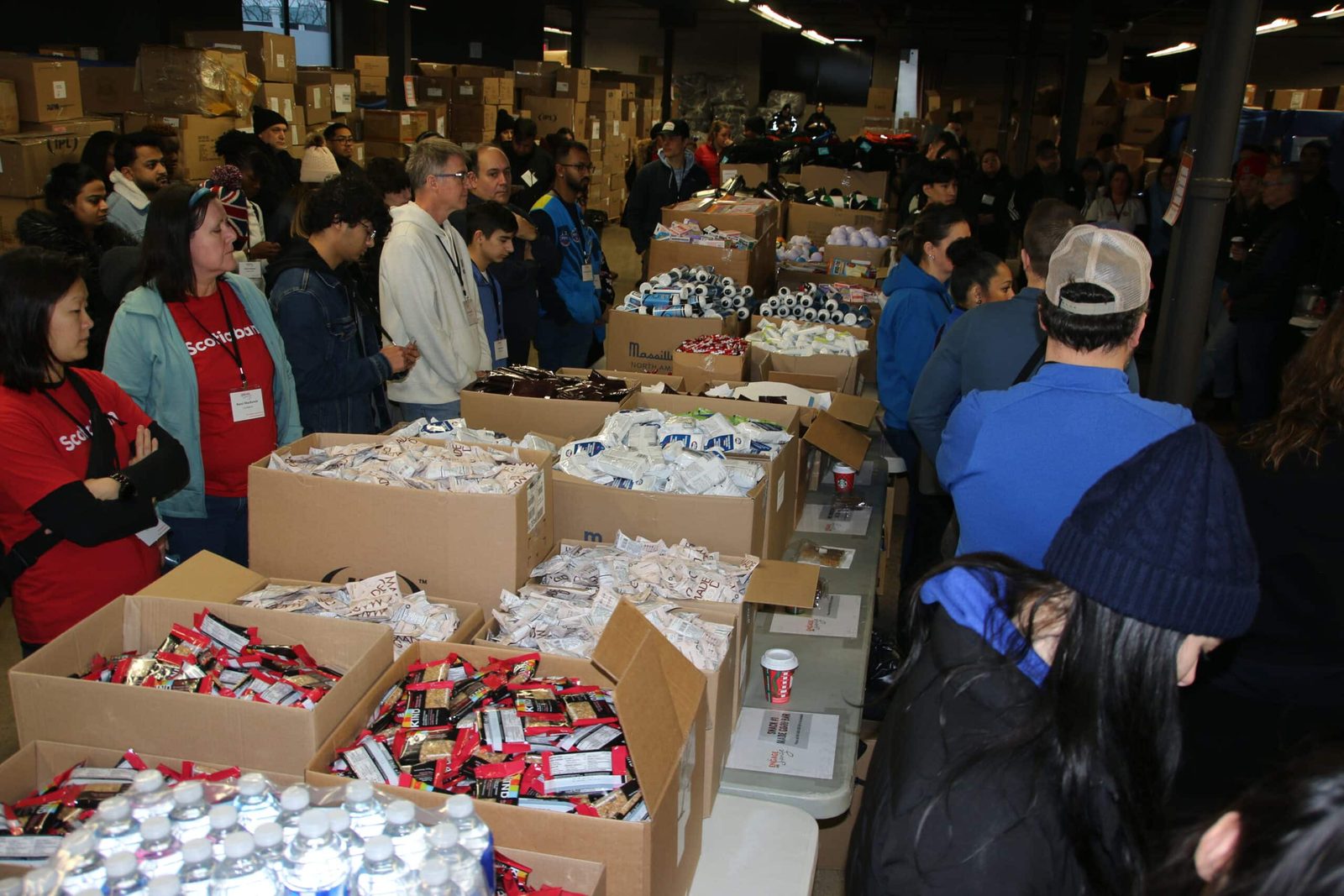 Hundreds of volunteers packing kits across the event floor