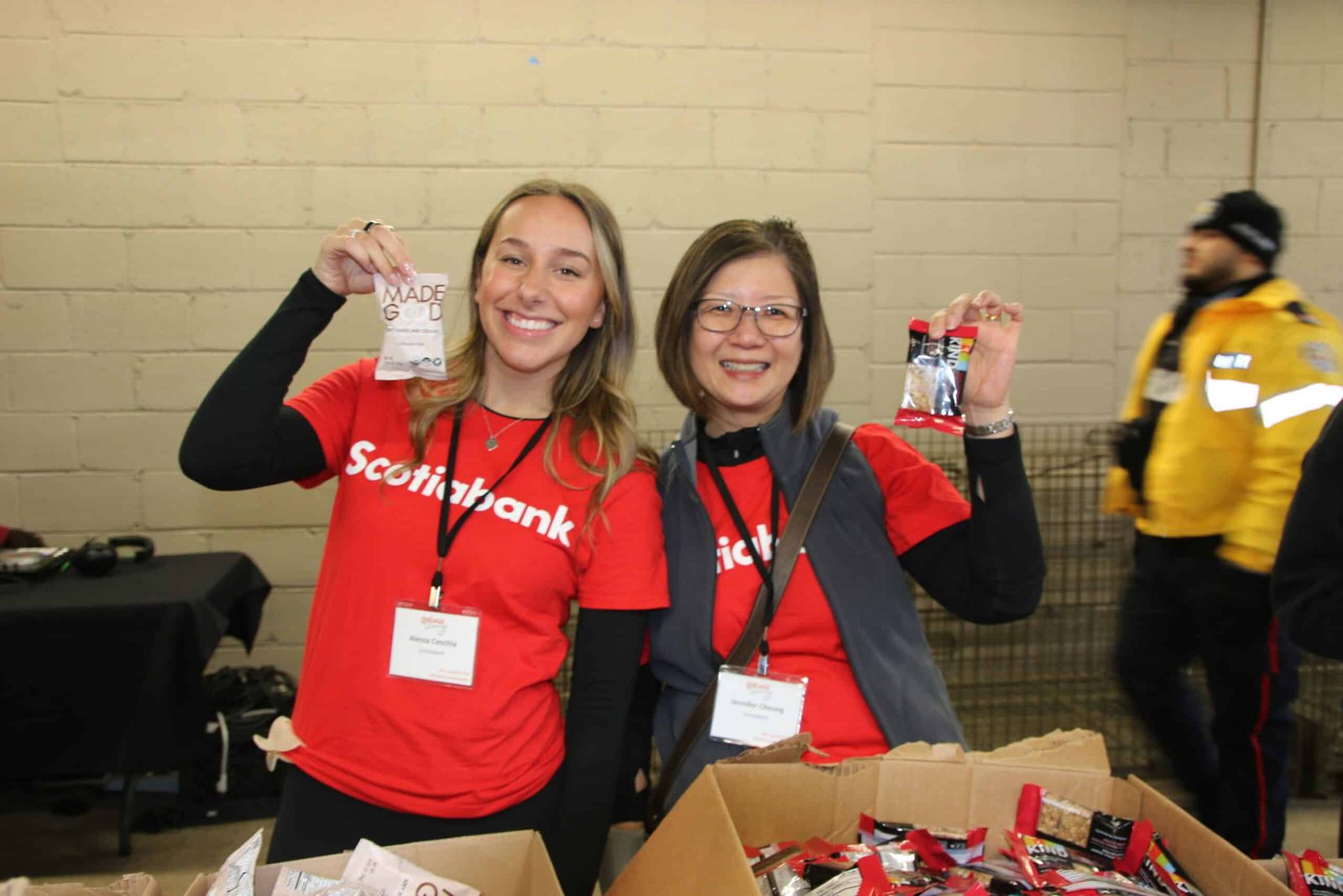 Two volunteers holding up finished kit backpacks